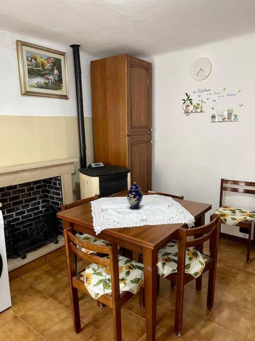 a dining room with a table and chairs and a fireplace at Casa vacanze Da Meryon in Albiano