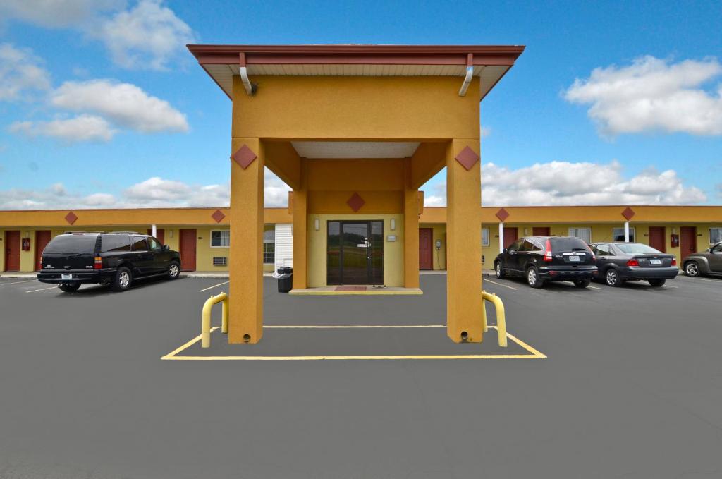 a large yellow building with cars parked in a parking lot at Charleston Eagle Inn in Charleston