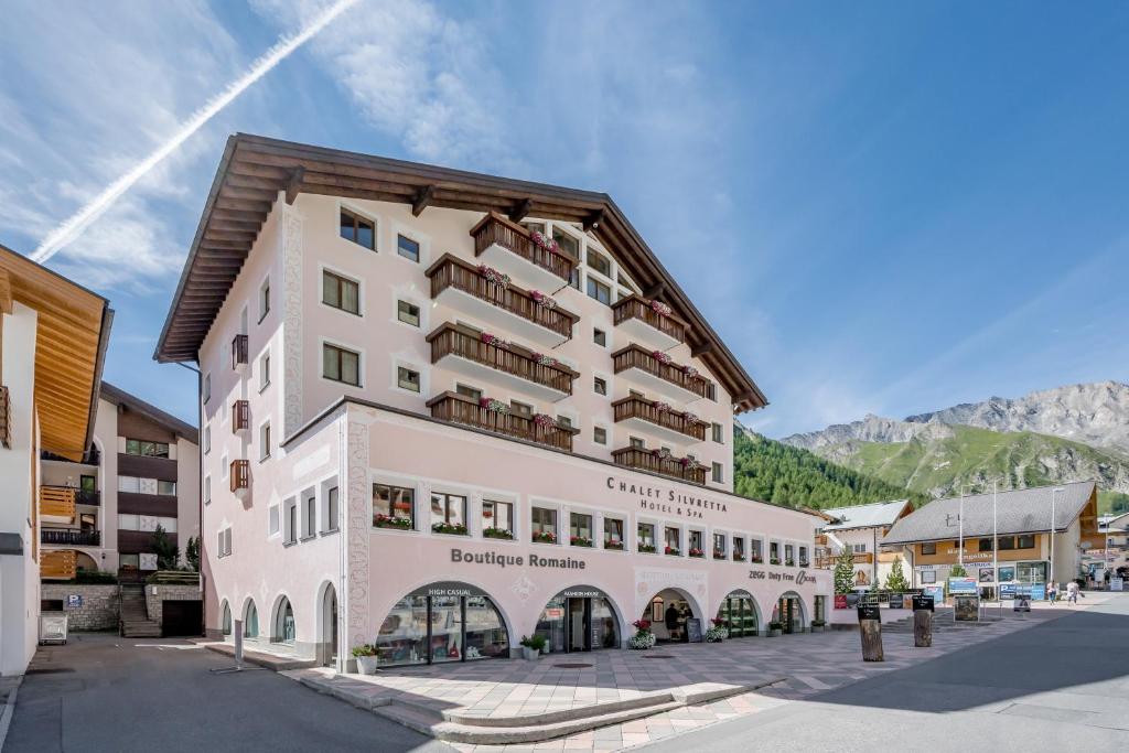 un gran edificio blanco frente a una montaña en Chalet Silvretta Hotel & Spa, en Samnaun