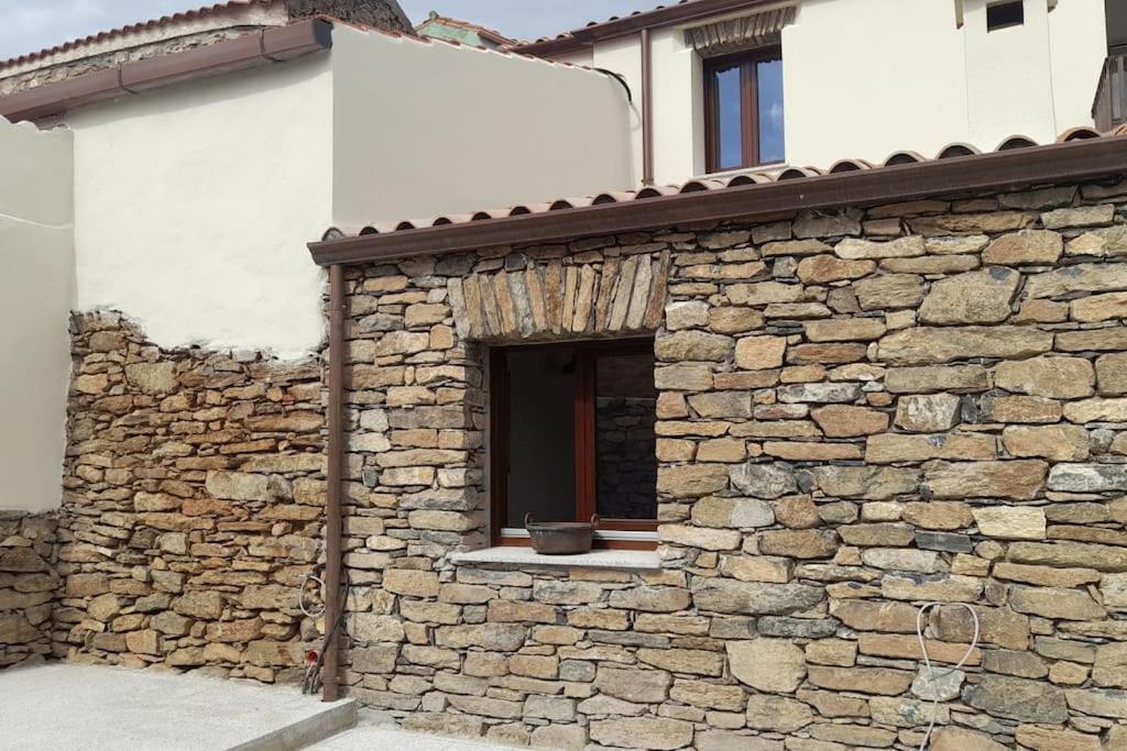 - un bâtiment en pierre avec une fenêtre sur le côté dans l'établissement Casa tipica nel borgo antico, à Armungia