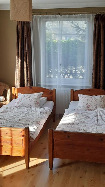2 camas en una habitación con ventana en Sominy 17 - Dom w sercu kaszubskiej wsi, en Sominy