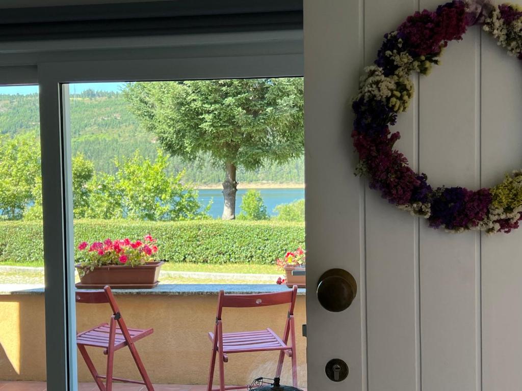 un porche con 2 sillas y una corona en la puerta en Casa d´Água en Venda Nova
