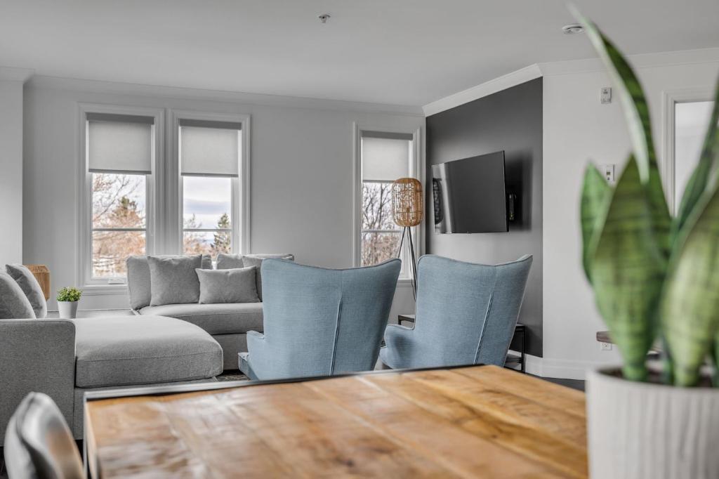 uma sala de estar com cadeiras azuis e uma mesa em INITIAL - HORIZON - Chutes-Montmorency em Boischâtel