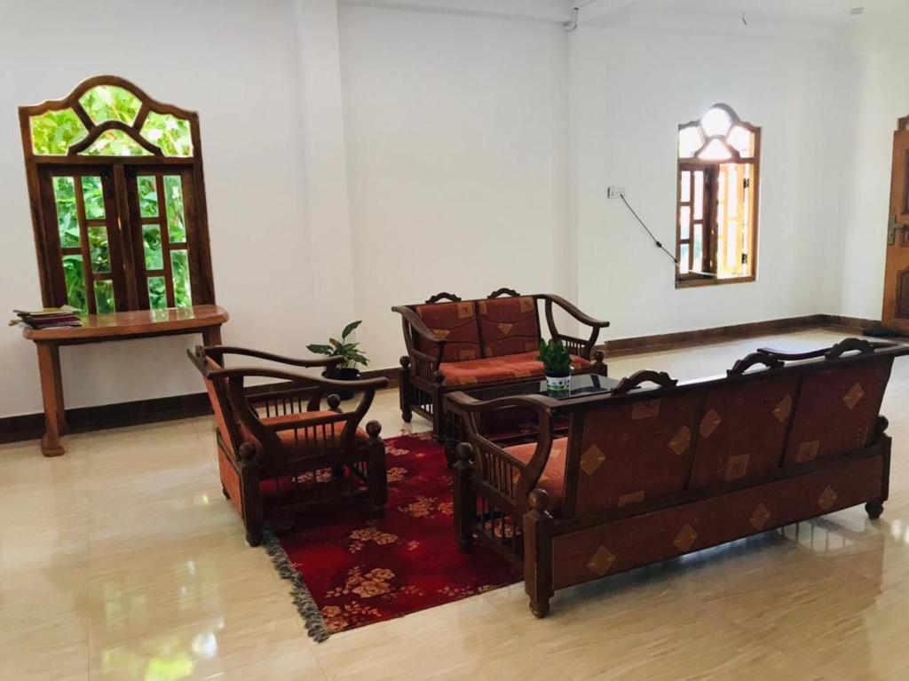 una sala de estar con 2 sofás y una alfombra roja en Pearl Rest en Mannar