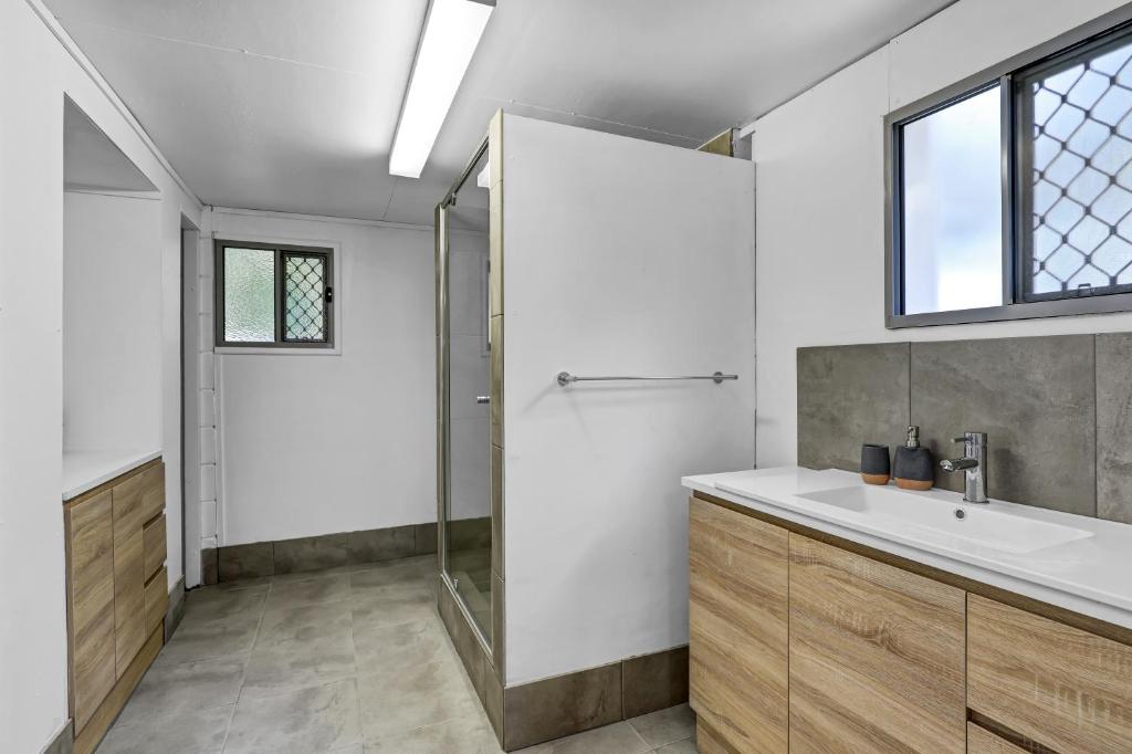 a bathroom with a sink and a shower at Billa Bungalow - 16 Billa Street in Point Lookout