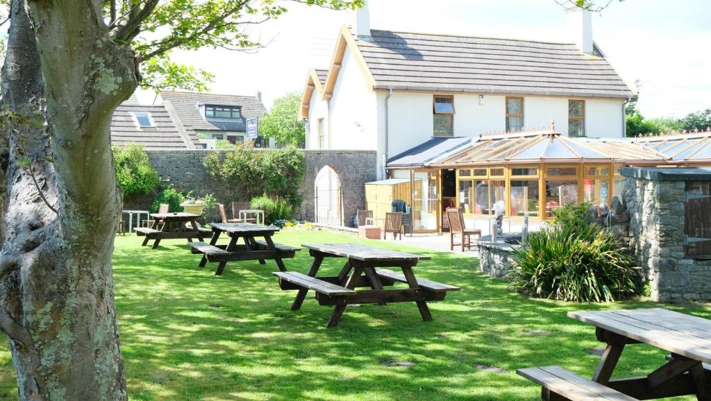 a group of picnic tables in a yard with a building at The Old Rectory - Brean in Brean