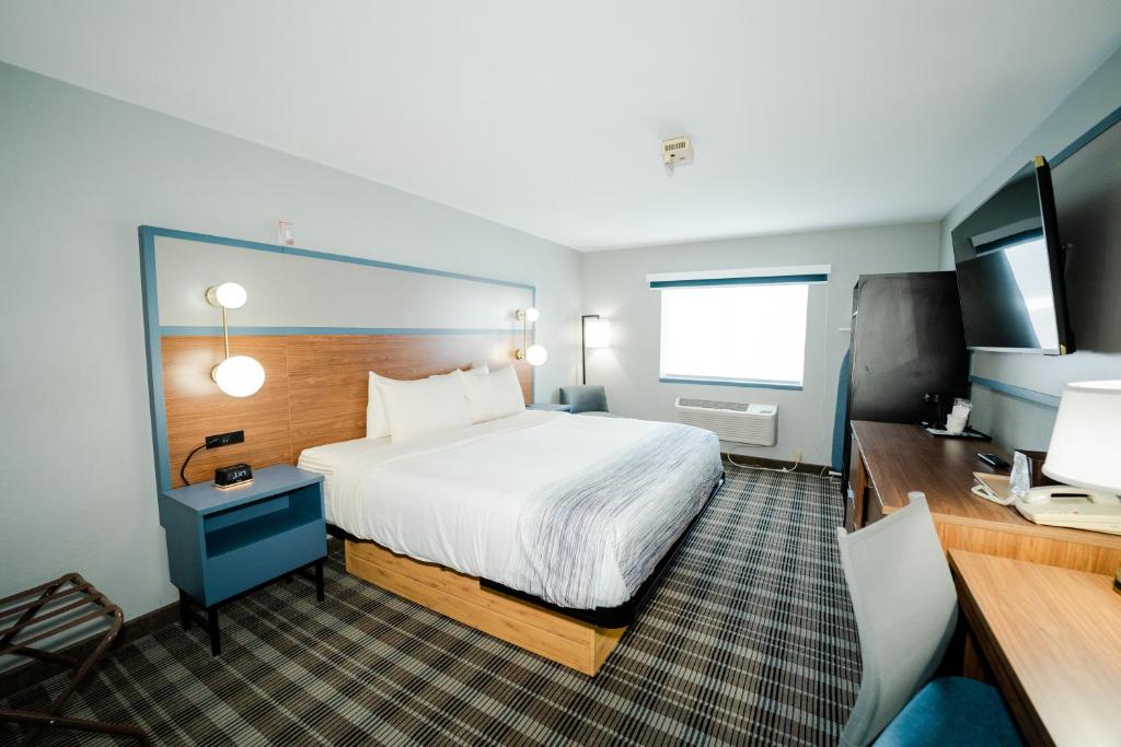 a hotel room with a bed and a television at AmericInn by Wyndham Tomahawk in Tomahawk