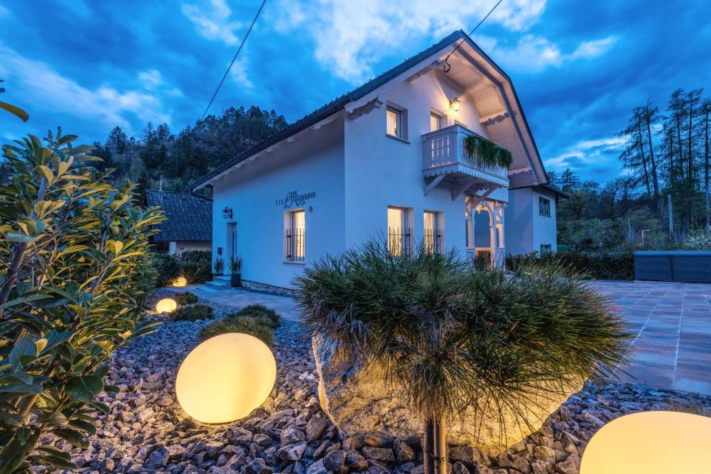 a white house with a balcony and plants at Vila Mignon in Bled