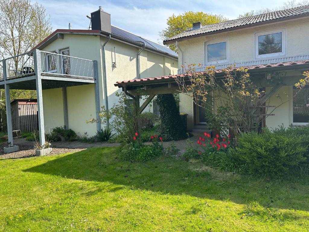 a house with a balcony and a yard at Monteurzimmer an der Schlei in Rabenkirchen-Faulück