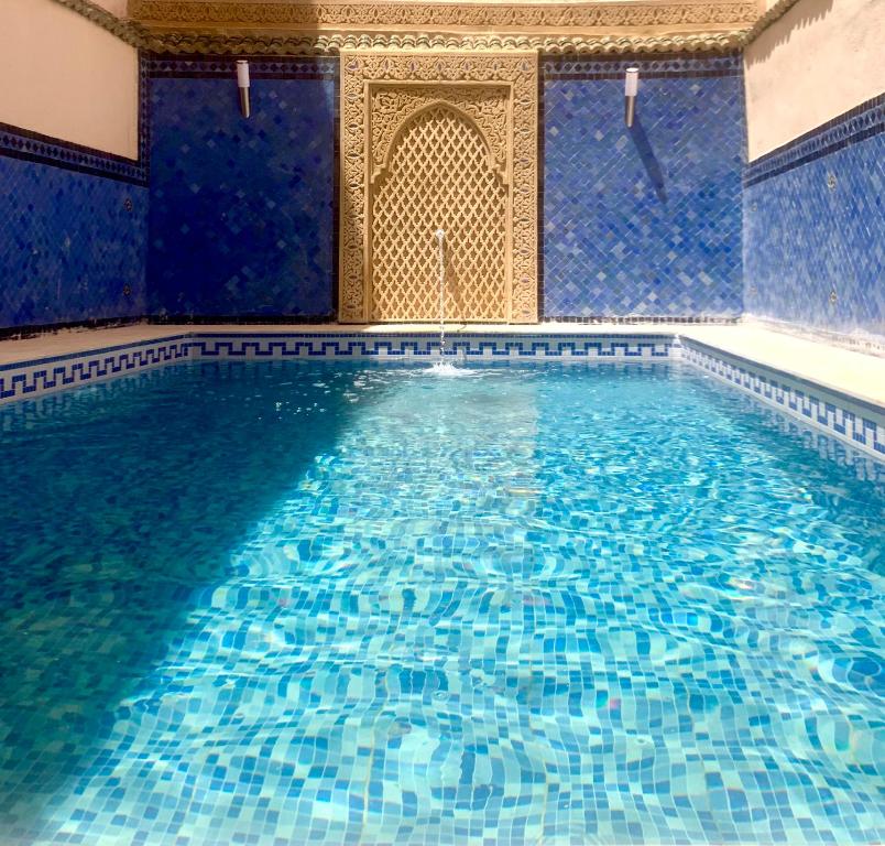 d'une piscine avec des murs carrelés bleus et d'une piscine d'hydromassage. dans l'établissement Riad Zahraa Al Ismailia, à Meknès