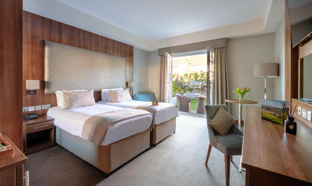 a bedroom with a bed and a desk and a chair at Formby Hall Golf Resort & Spa in Southport