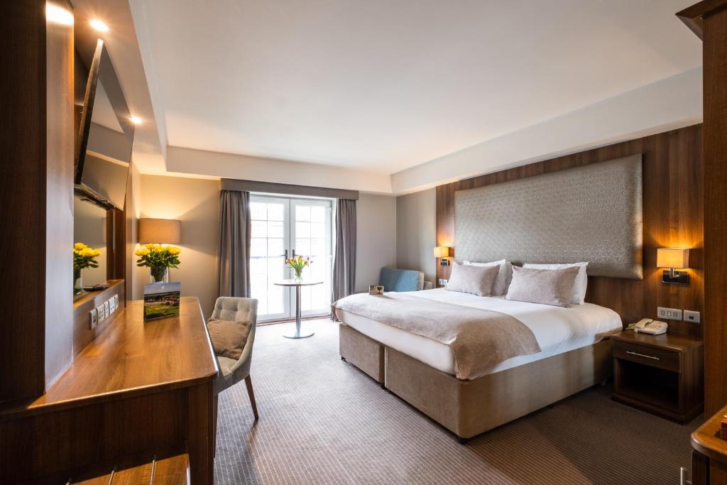 a hotel room with a bed and a desk at Formby Hall Golf Resort & Spa in Southport