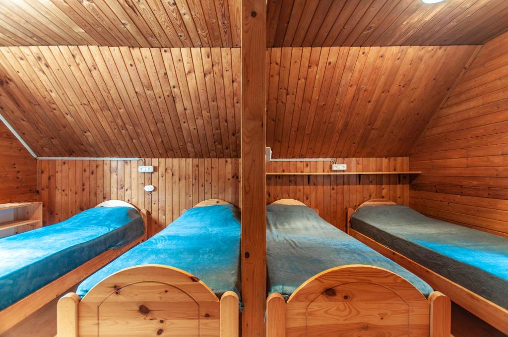 two beds in a sauna with wooden walls at Mala koča Wooden Cabin in Goreljek