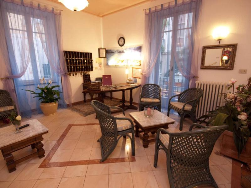 アラッシオにあるHotel Experiaのリビングルーム(椅子、テーブル、テーブル、椅子付)