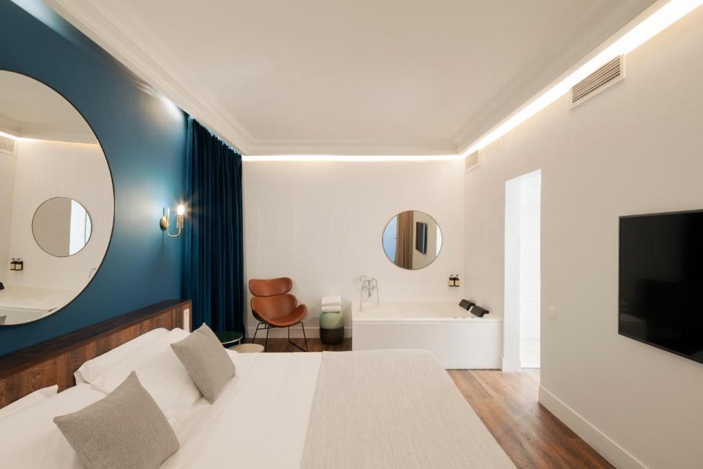 a bedroom with a white bed and a bathroom at H Regas Adults Only in Barcelona