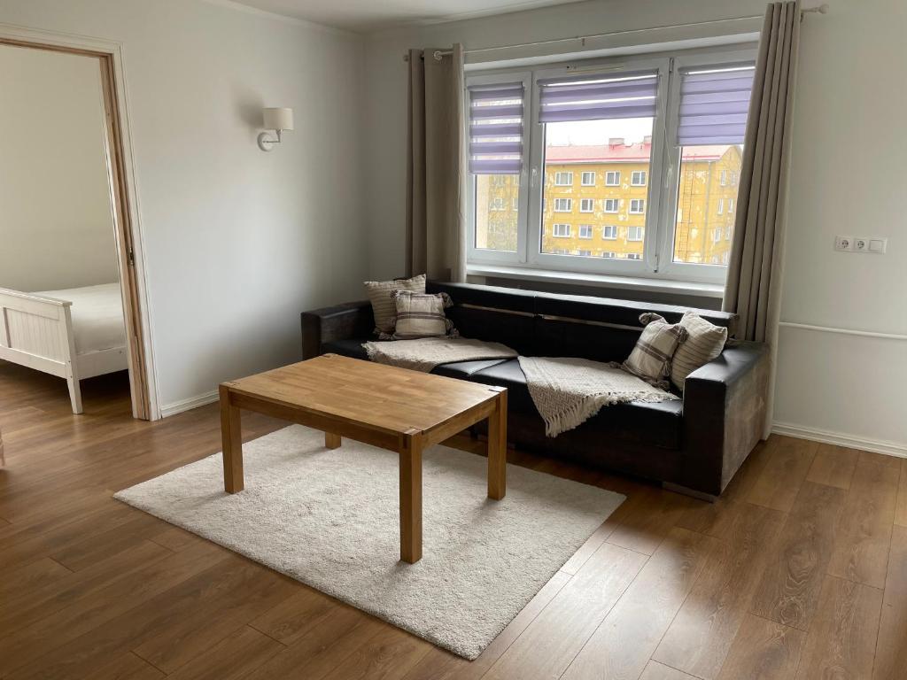 a living room with a black couch and a table at Cozy apartment near TalTech and Elamus SPA in Tallinn