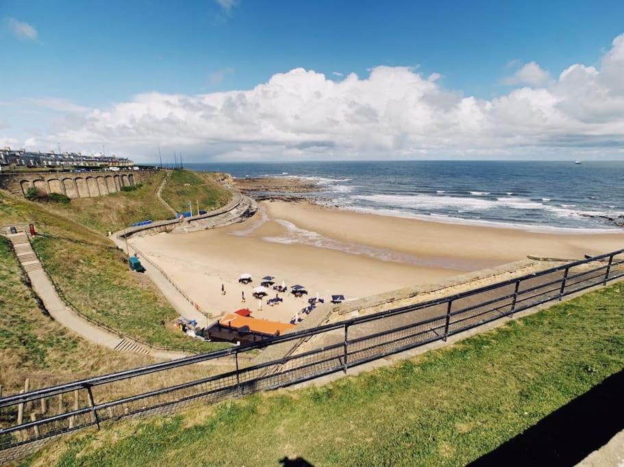 una playa con coches aparcados en la arena y el océano en Tynemouth Seaside 3 Bed House Close to Beach/Bars/Restaurants - Parking Space Included, en Tynemouth