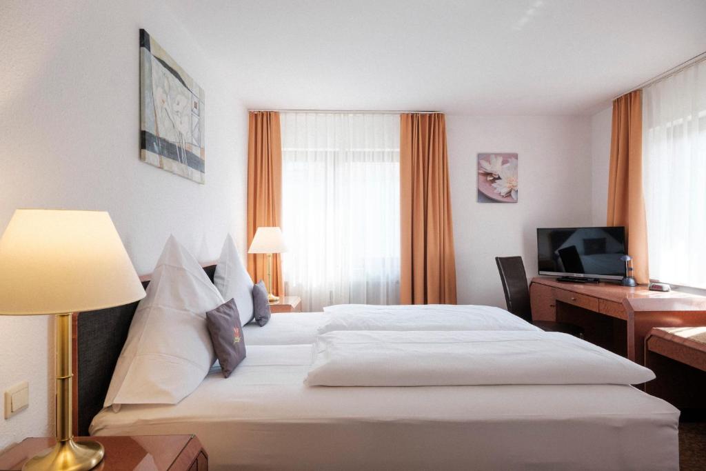 Postel nebo postele na pokoji v ubytování Hotel Flora Möhringen