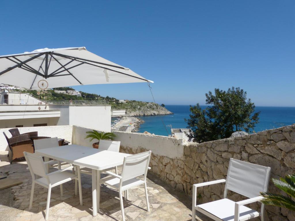 una mesa y sillas con sombrilla y el océano en Casa Vacanze Vincenzo e Rosanna, en Castro di Lecce