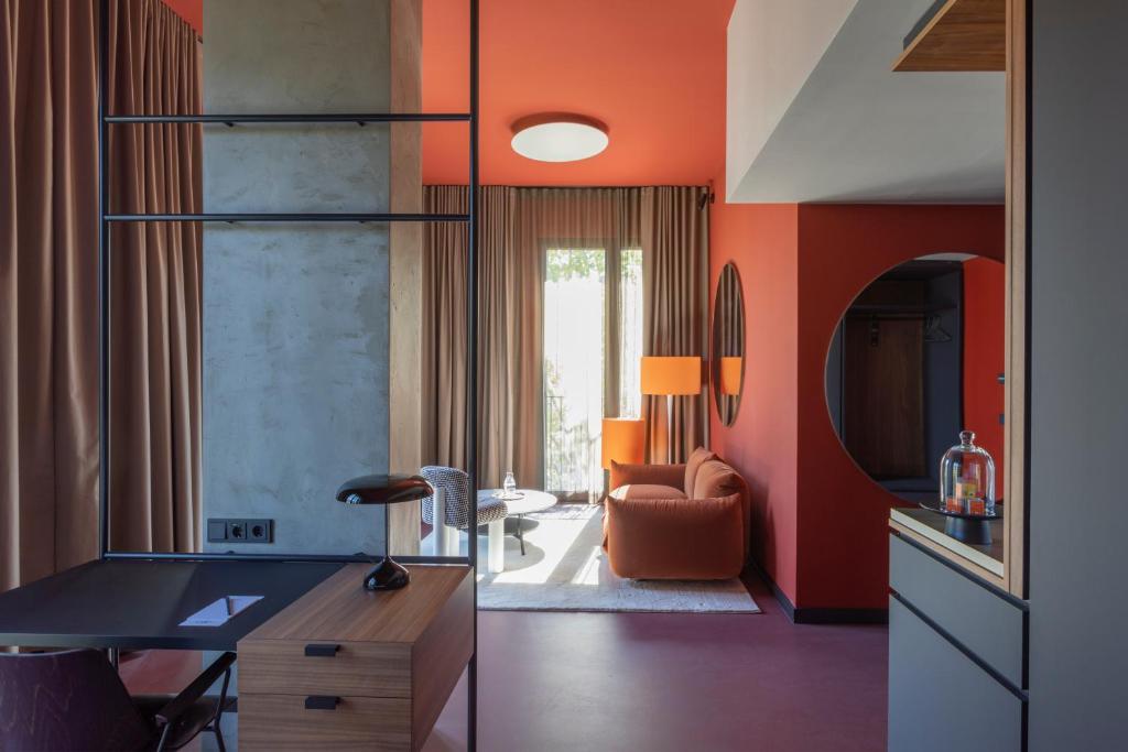 un soggiorno con pareti arancioni e scrivania di EmiLu Design Hotel a Stoccarda