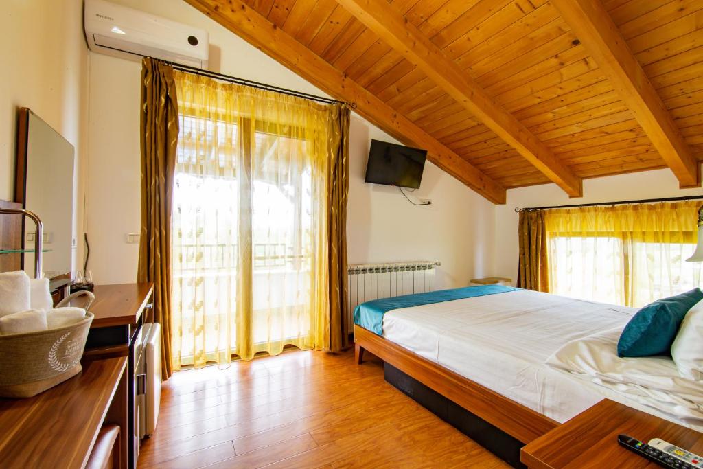 1 dormitorio con cama y ventana grande en Pensiunea Pestisorul, en Dunavăţu de Jos