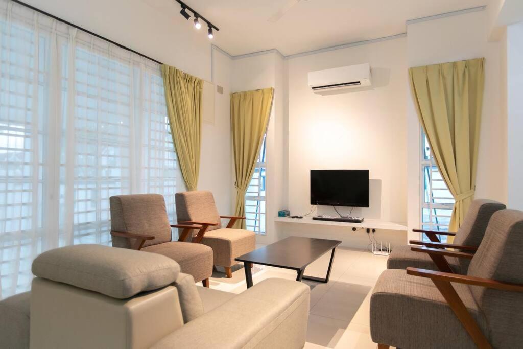 uma sala de estar com um sofá e cadeiras e uma televisão em Penang Balik Pulau Swimming Pool BBQ Homestay em Balik Pulau
