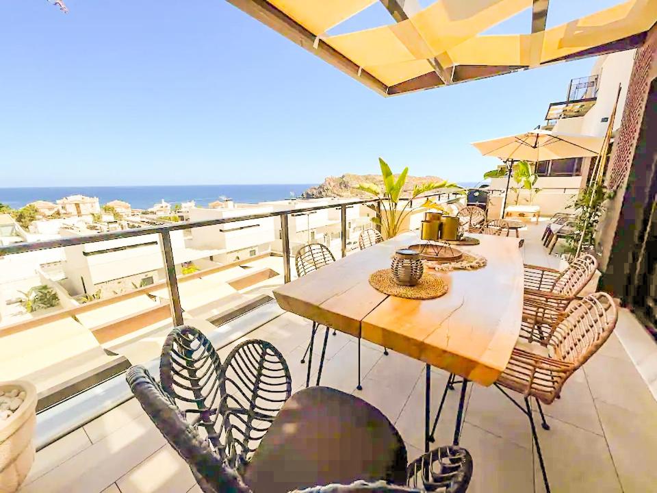 Luxury Designer Apartment - Unbeatable Sea Views في أغيلاس: طاولة وكراسي على شرفة مع المحيط