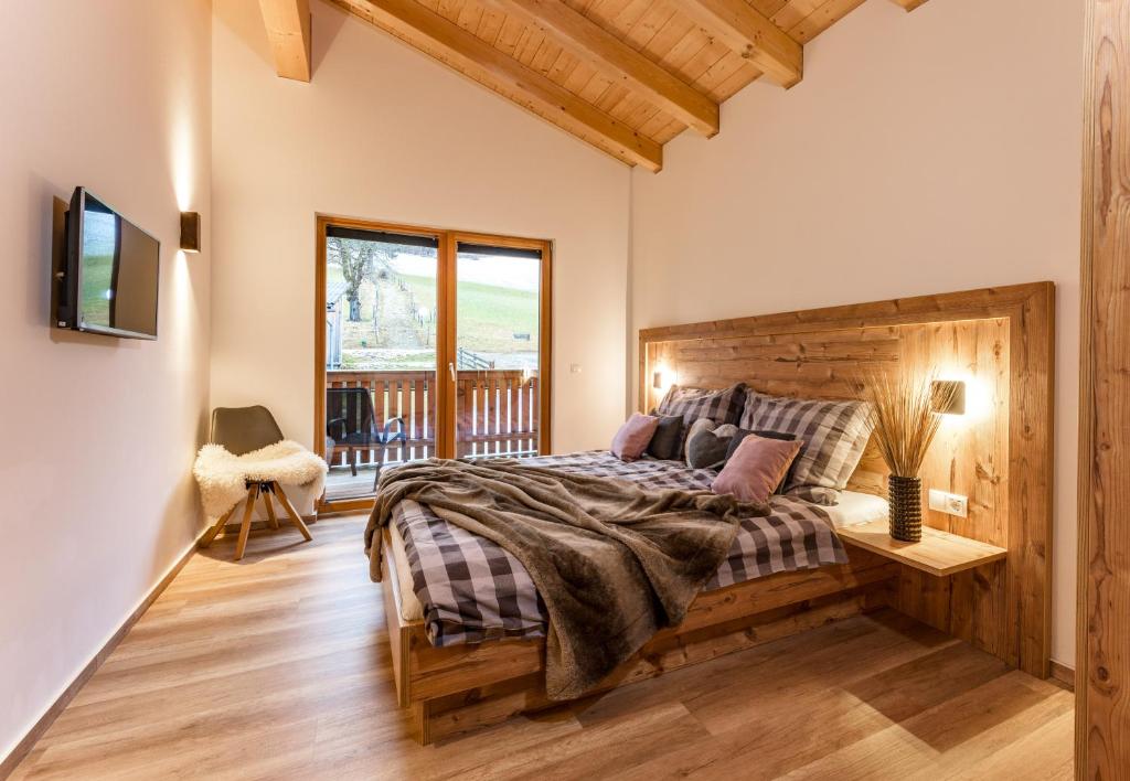 um quarto com uma cama grande e uma varanda em Piekvier lodge em Schladming