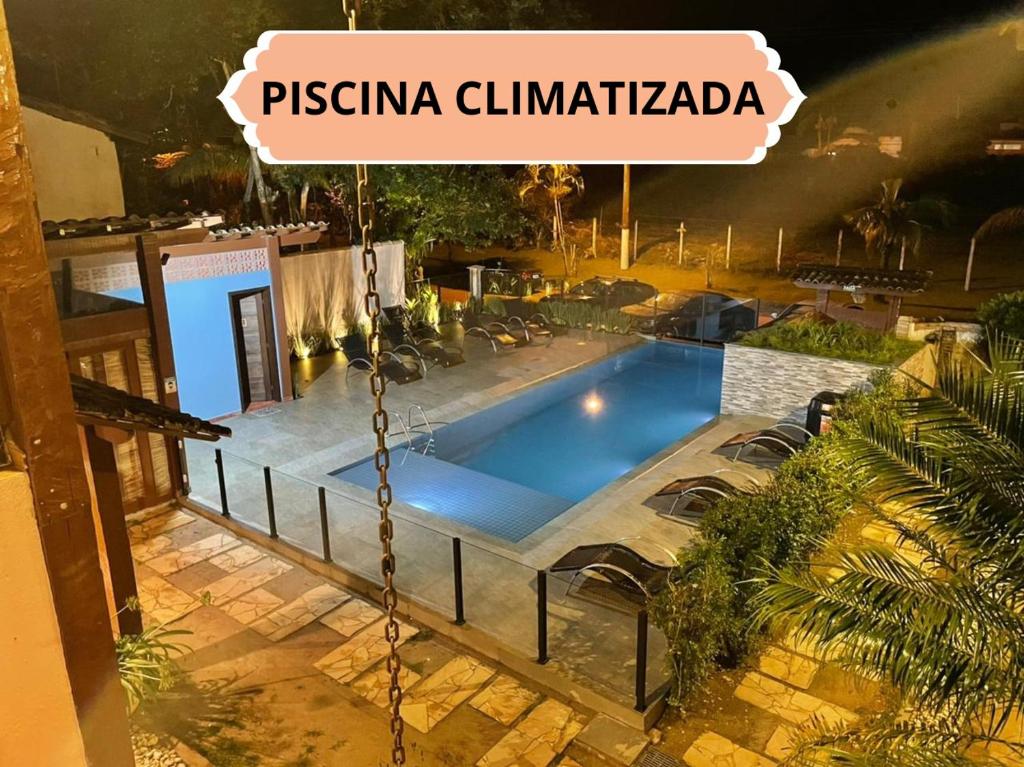 ein Schwimmbad mit einem Schild, das Pistina climabilidad liest in der Unterkunft Apartamentos para locação em Ubatuba in Ubatuba
