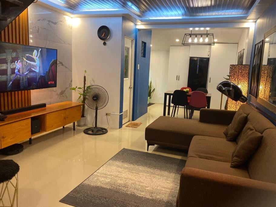 a living room with a couch and a flat screen tv at AGN Transient House in Naga