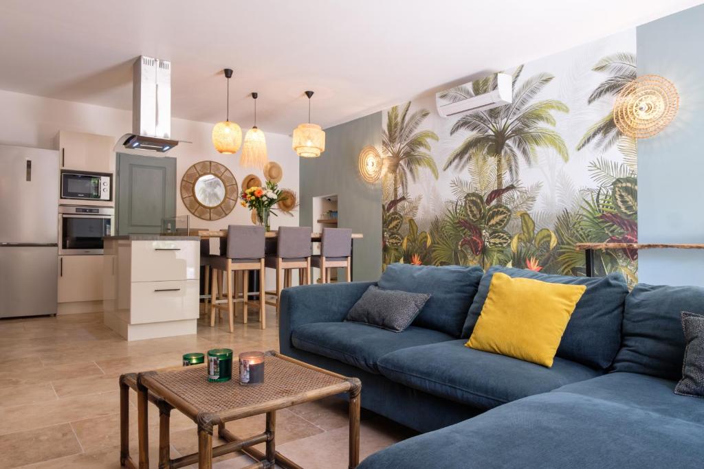 un salon avec un canapé bleu et une cuisine dans l'établissement Mas 9 Romanin - Mas Provençal Familial, à Saint-Rémy-de-Provence