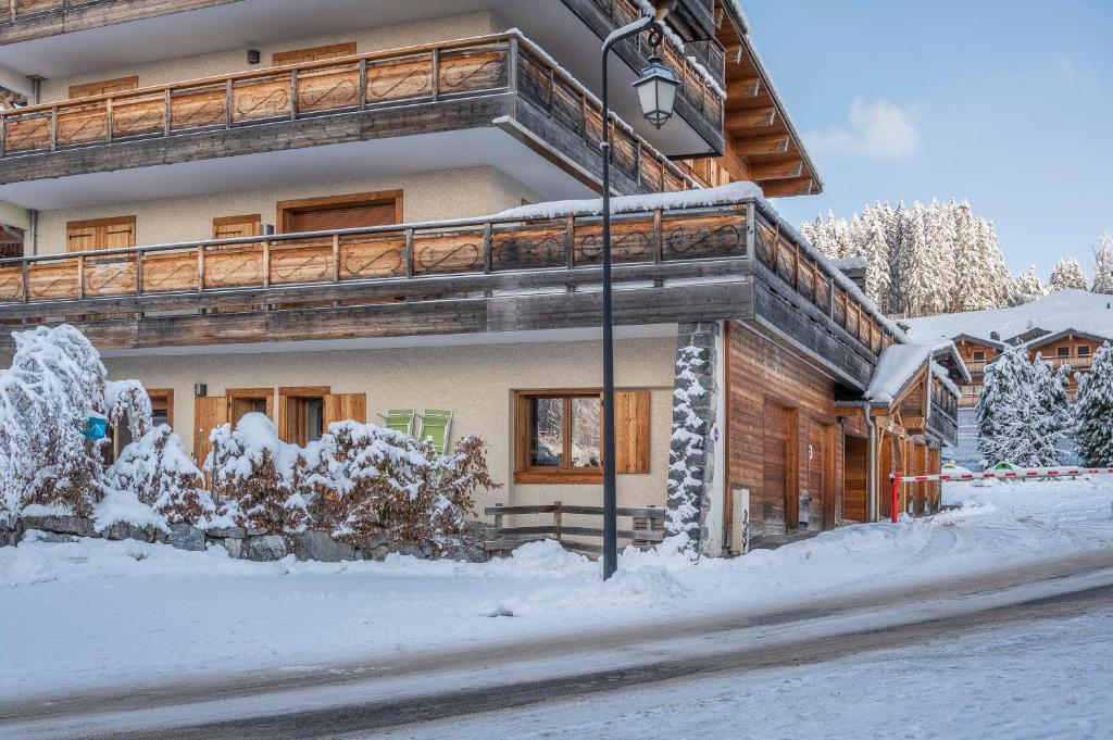 dom w zimie z śniegiem na ziemi w obiekcie Apartment Les Alpages w mieście Les Gets