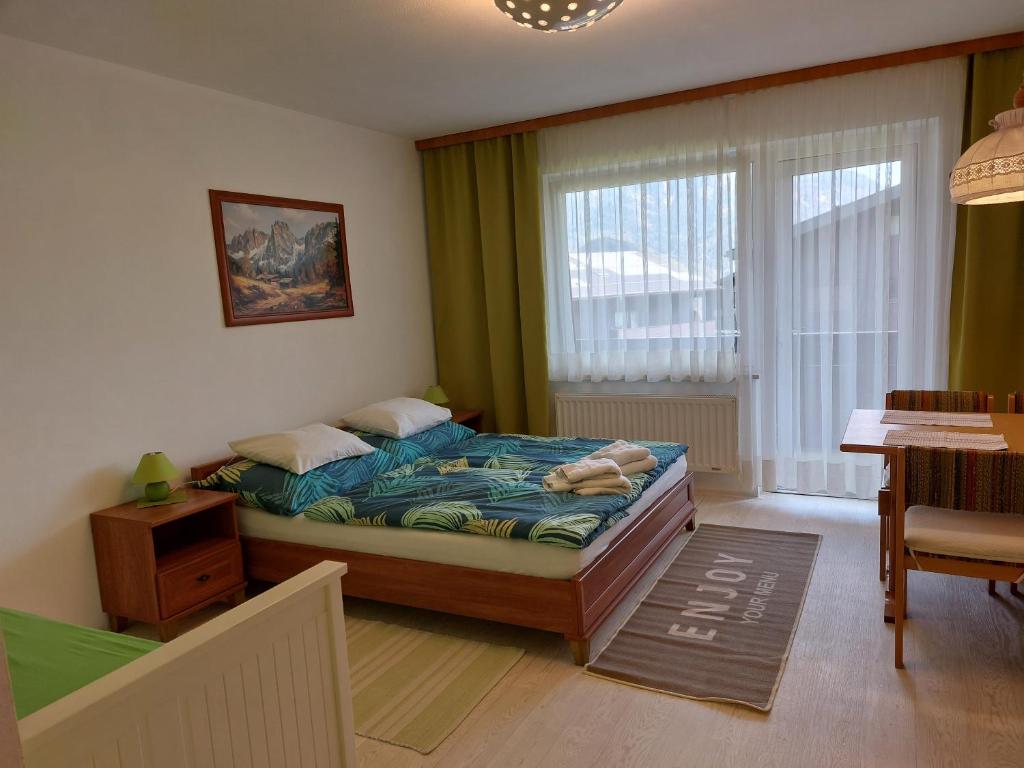 ザンクト・ギルゲンにあるFerienwohnung Studio 6 Bergblickのベッドルーム1室(ベッド1台、テーブル、窓付)