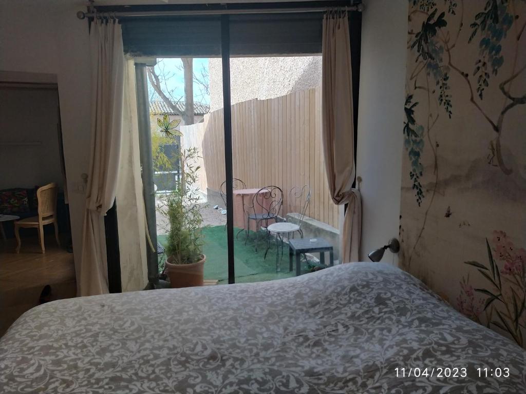 - une chambre avec un lit et une vue sur le jardin dans l'établissement la maison de josy, à Aix-en-Provence