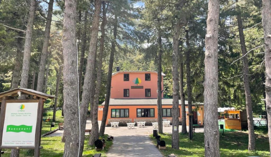 a large orange building in the middle of a forest at La Pinetina in San Massimo