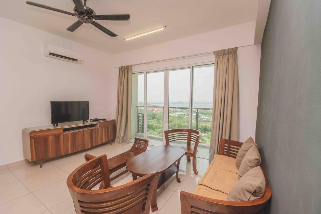 峇六拜的住宿－3 bedroom condo with Pool near Queensbay Mall，客厅配有桌椅和电视。