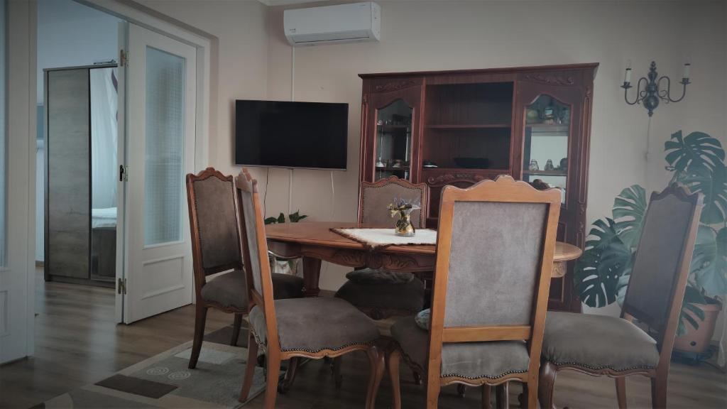 uma sala de jantar com uma mesa de madeira e cadeiras em Apartament Victoria em Baile Felix
