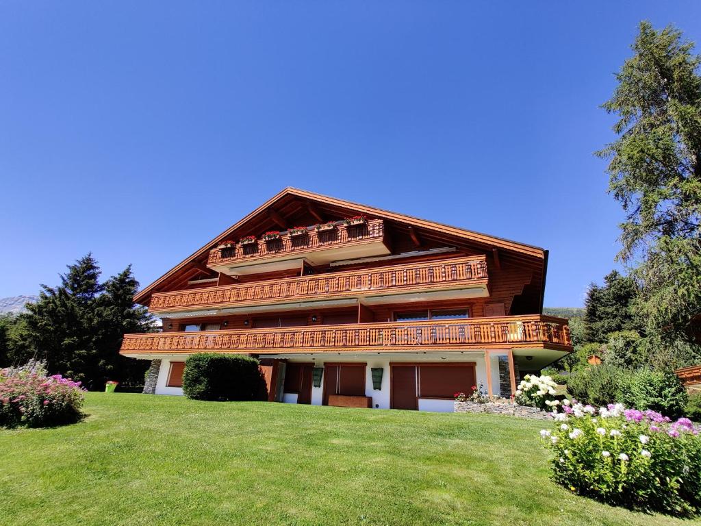 una casa grande en la cima de una colina con césped en Beau Vallon 04, en Crans-Montana