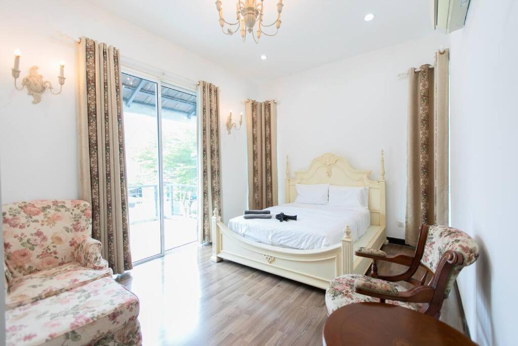 1 dormitorio con 1 cama, 1 silla y 1 ventana en Teluk Bahang European Style SemiD 4 Bedrooms 10ppl, en Teluk Bahang