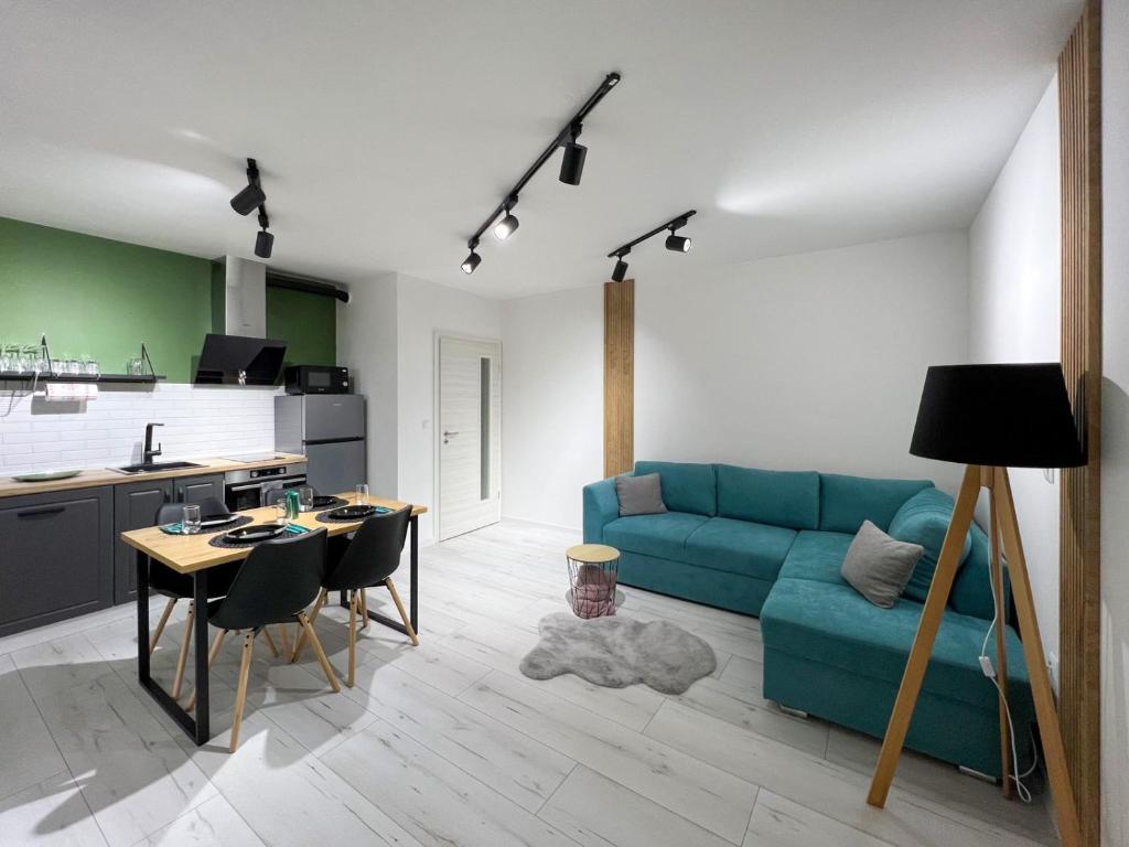 ein Wohnzimmer mit einem blauen Sofa und einem Tisch in der Unterkunft SOS CoMFORT 2 LAZUR in Burgas City