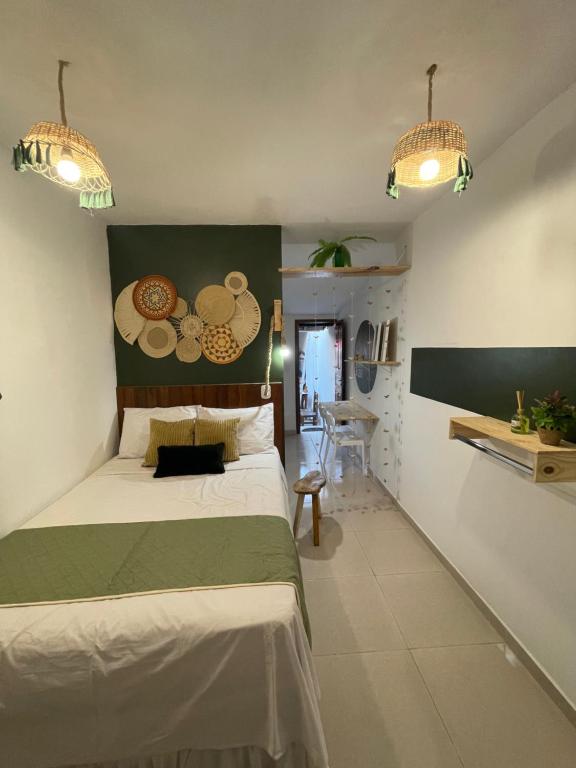 a bedroom with a bed and two pendant lights at AP1 Atrás da passarela do caranguejo - Orla de Atalaia in Aracaju