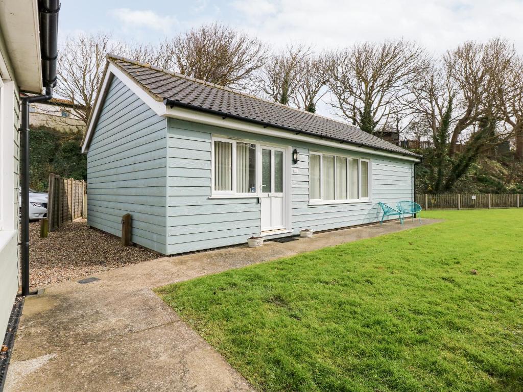 a small blue house with a grass yard at 1 The Dell in Norwich