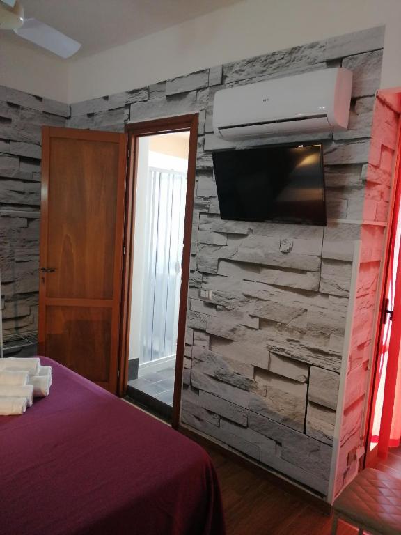 Televízia a/alebo spoločenská miestnosť v ubytovaní Le Rocce Holiday Rooms