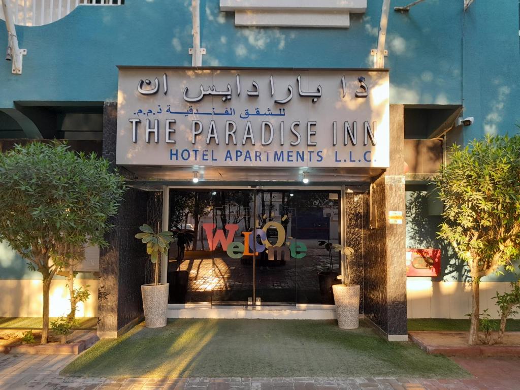 ein Gebäude mit einem Schild, das das paradiesische Gasthaus liest in der Unterkunft Paradise Inn Hotel (Tabasum Group) in Ajman 