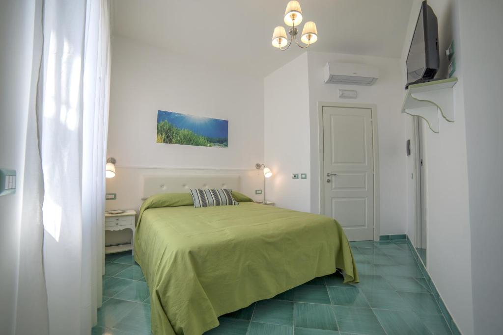 1 dormitorio con 1 cama con manta verde en B&B Amalba Maiori, en Maiori