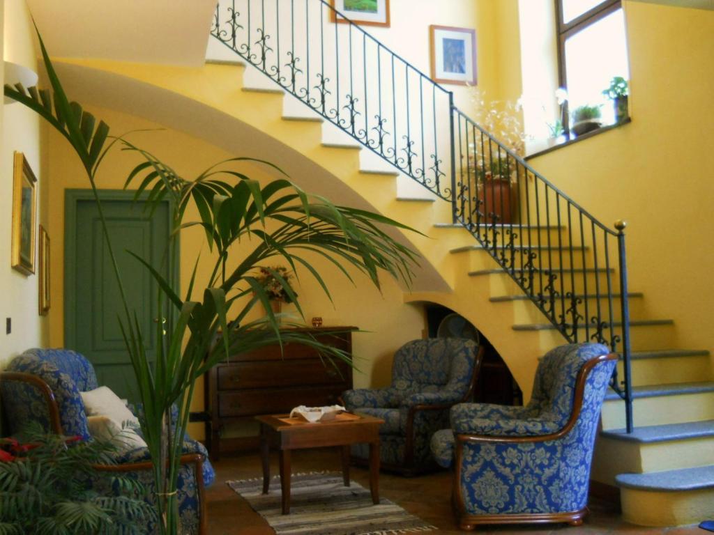 een woonkamer met 2 stoelen en een trap bij Tenuta Calabiana in Diano dʼAlba