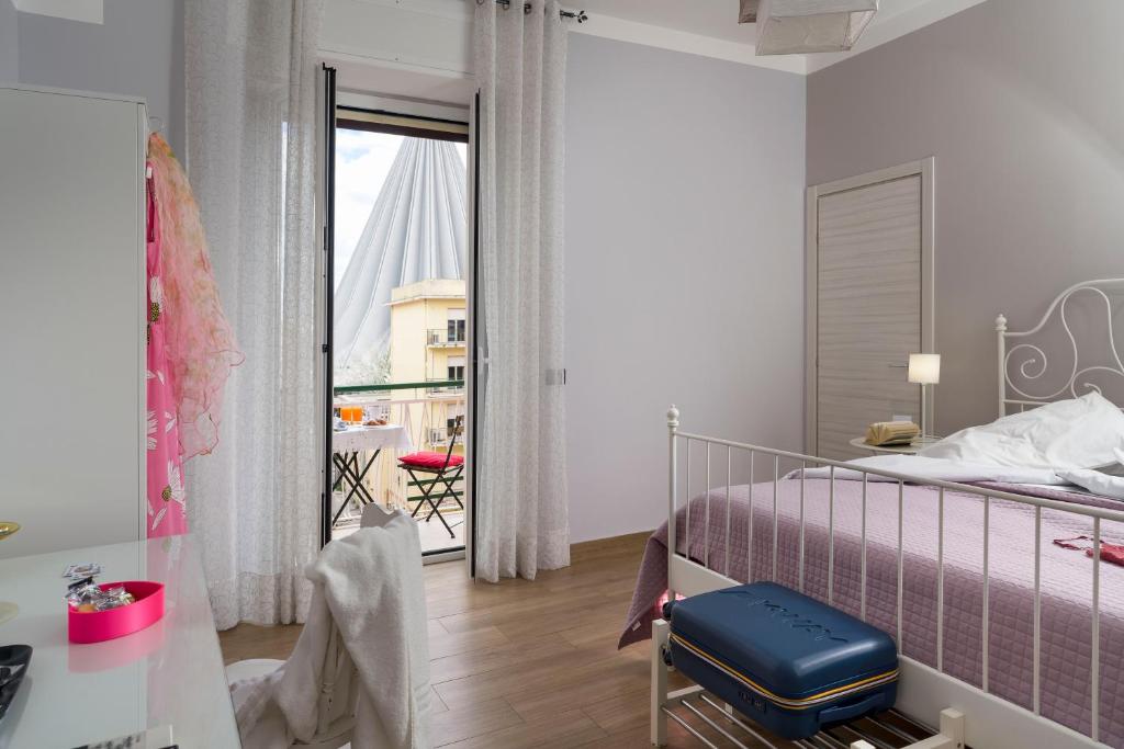 a bedroom with a purple bed and a balcony at Il Tempio di Athena - Cultura e Relax a Siracusa in Siracusa