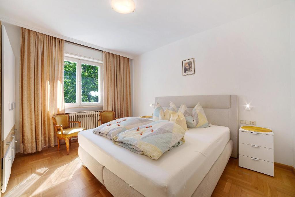 a bedroom with a large white bed and a window at Villa Sabine - Renate in Merano