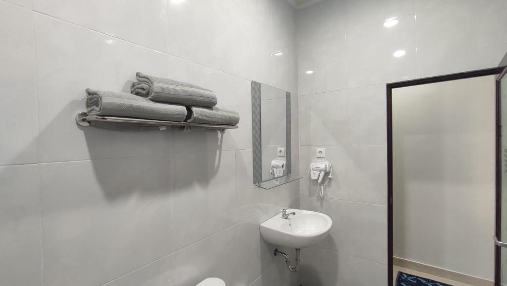 uma casa de banho branca com um lavatório e um espelho em Gubuk Ndeso Homestay em Bromo