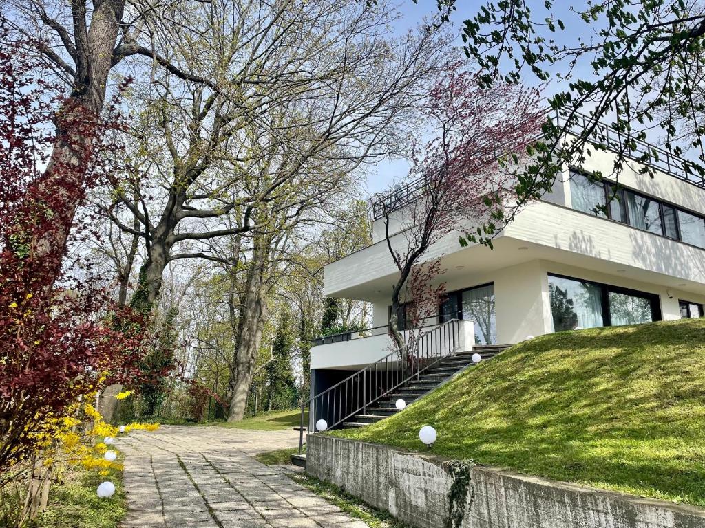 ein weißes Haus mit einem Grashügel davor in der Unterkunft Porsche Villa mit Garten und Garage in Bestlage von Döbling in Wien in Wien